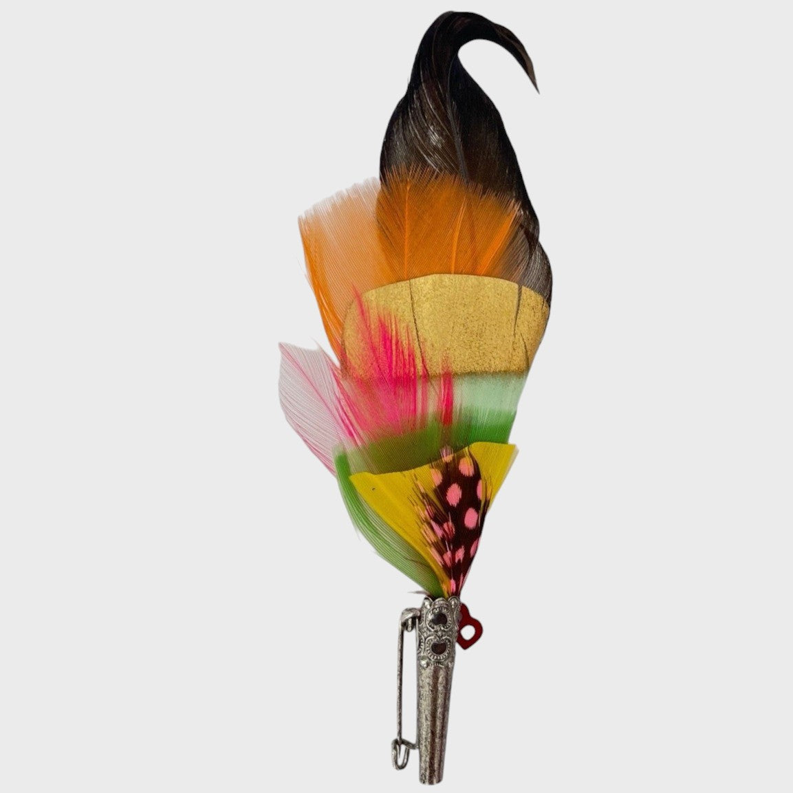 Orange, black and yellow feathered brooch on a light gray background