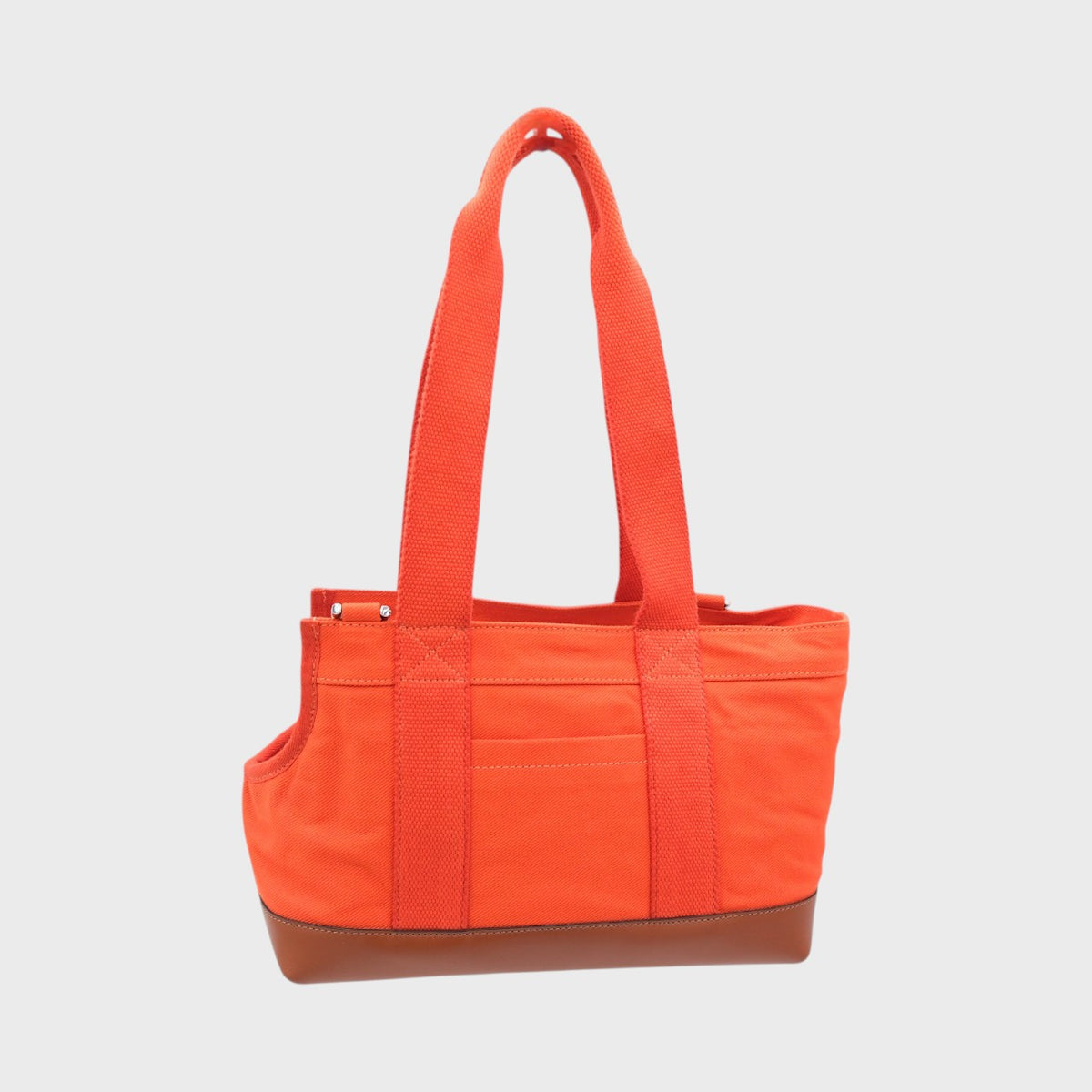 Orange dog bag with a brown leather base on a light gray background