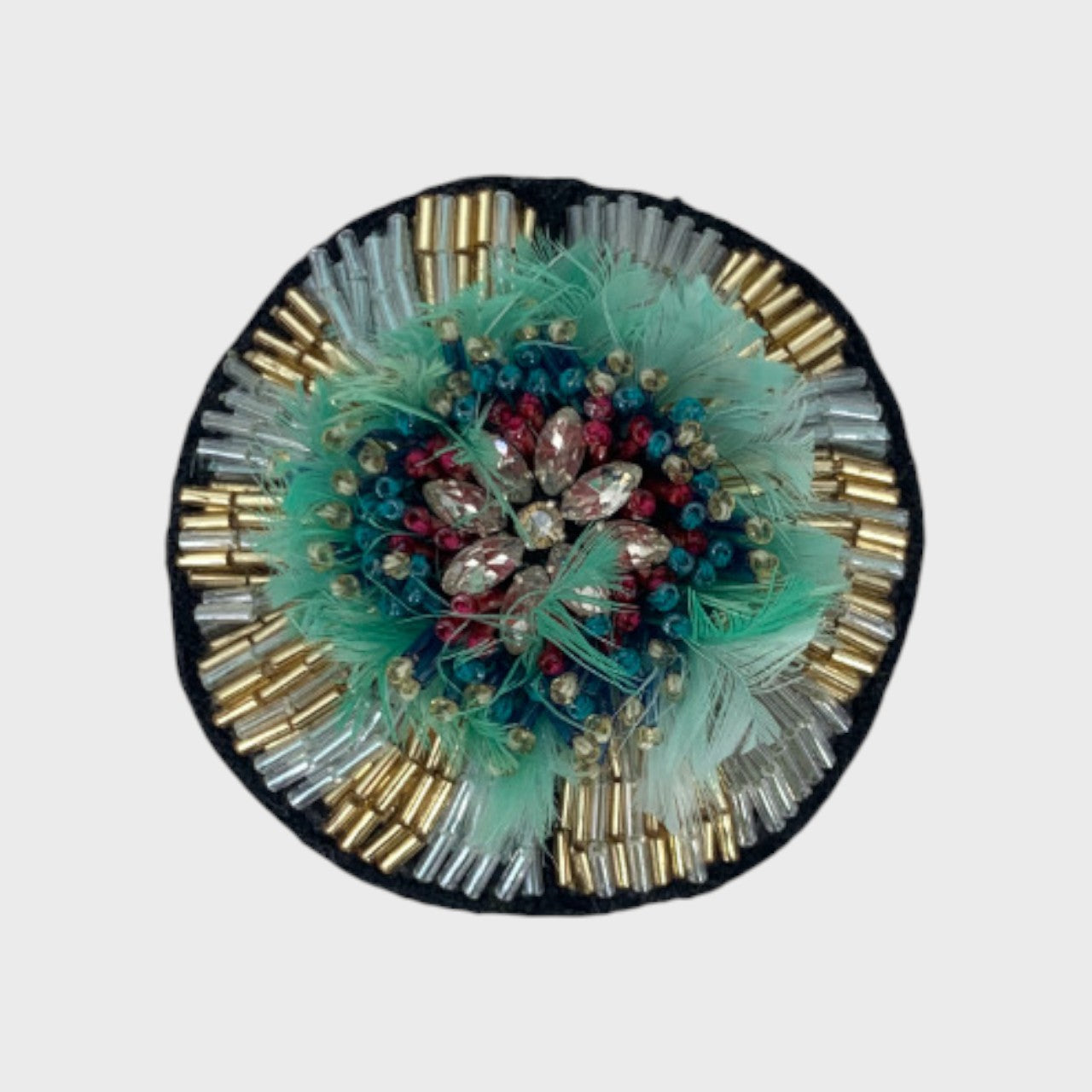 An embroidered brooch representing a passiflora with blue, white and red details. 