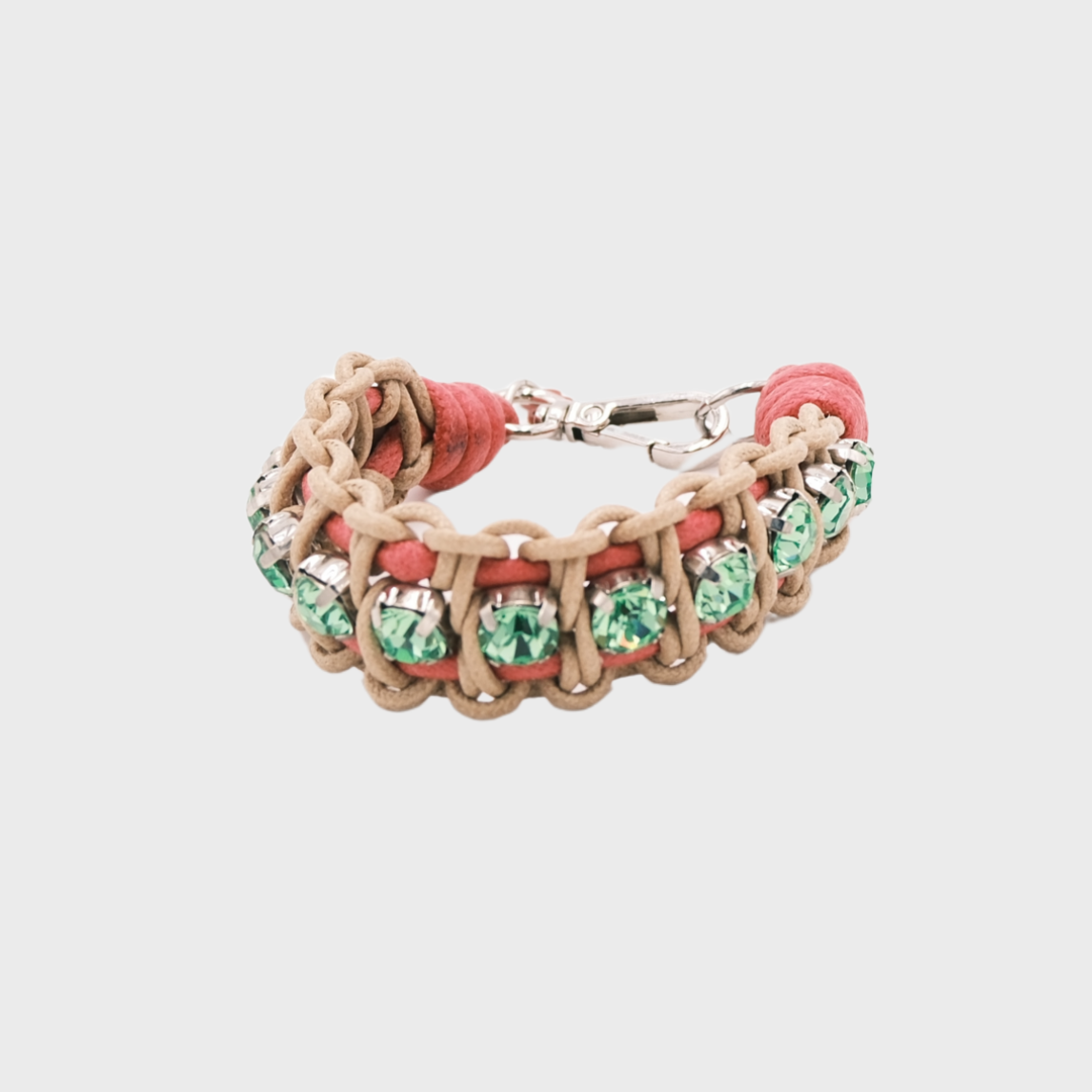 A braided macramé bracelet featuring beige and pink cords with small green beads.