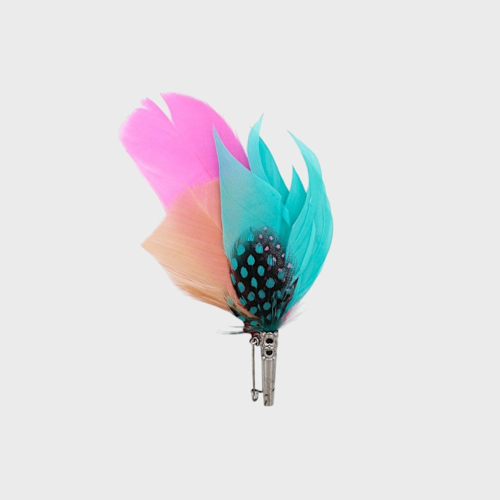 Pink, blue and black feathered brooch on a light gray background