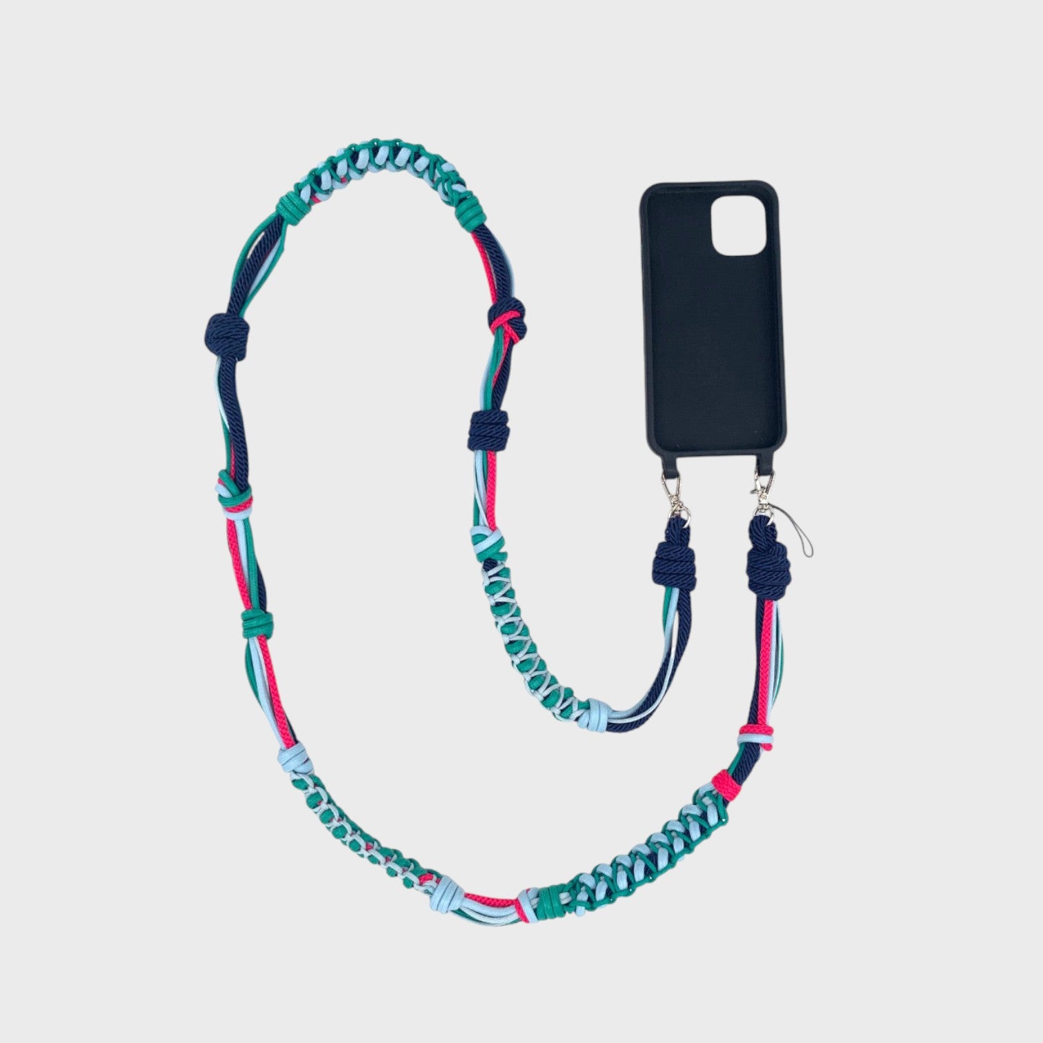 Green, light and dark blue and pink macramé thick woven phone lanyard with a black phone case on a white background. 