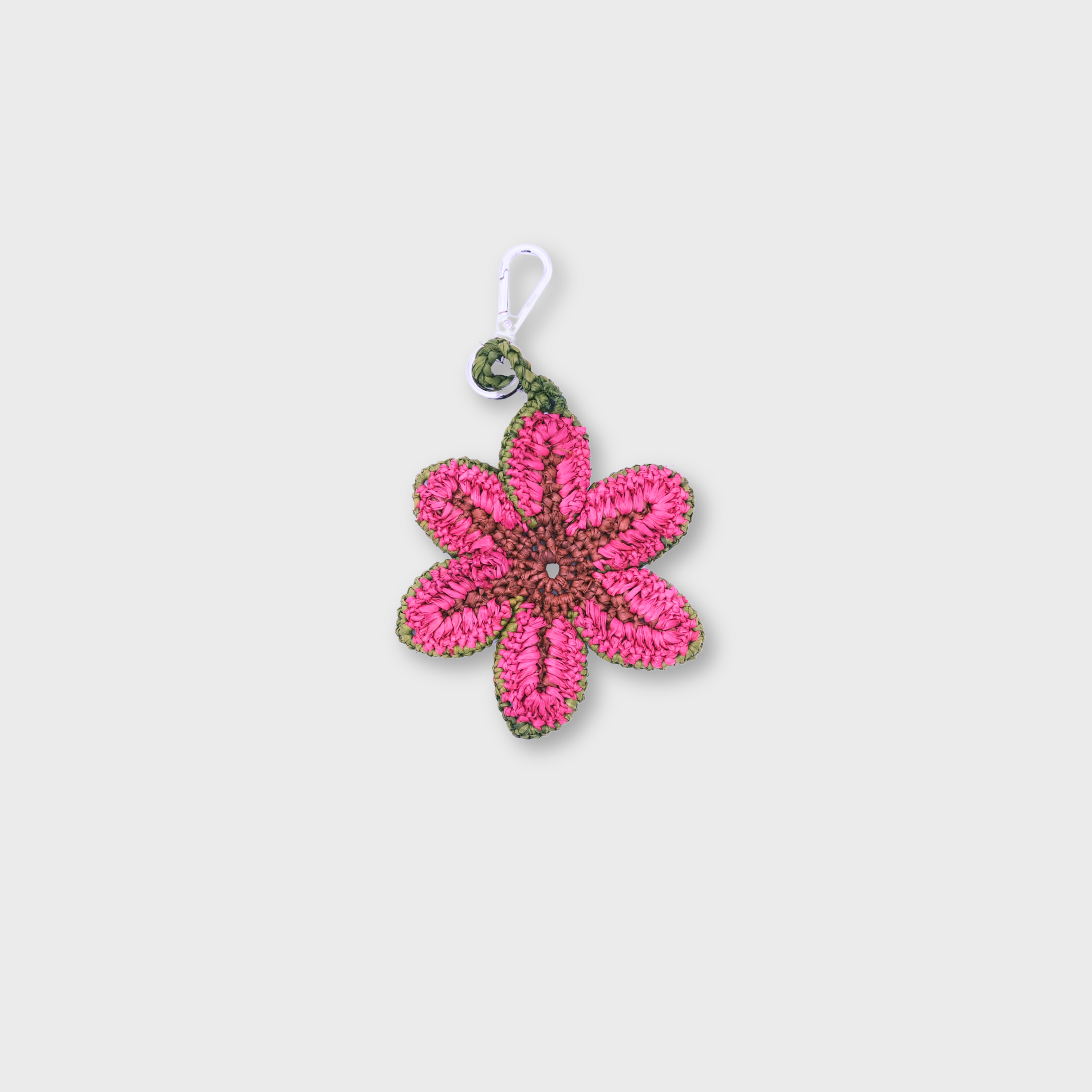 A raffia pink bag charm representing a flower. 