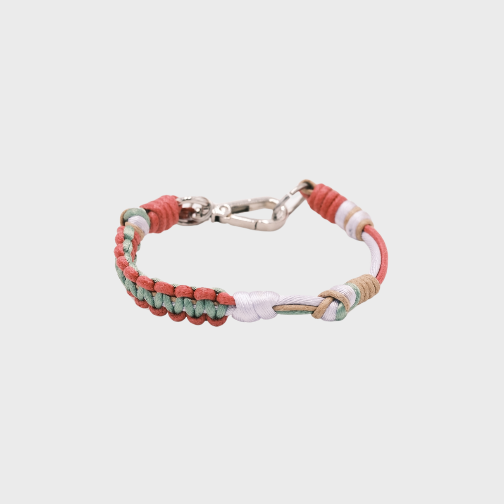 A thin braided bracelet with pink, green and light brown macramé, featuring a silver metal  clasp. 