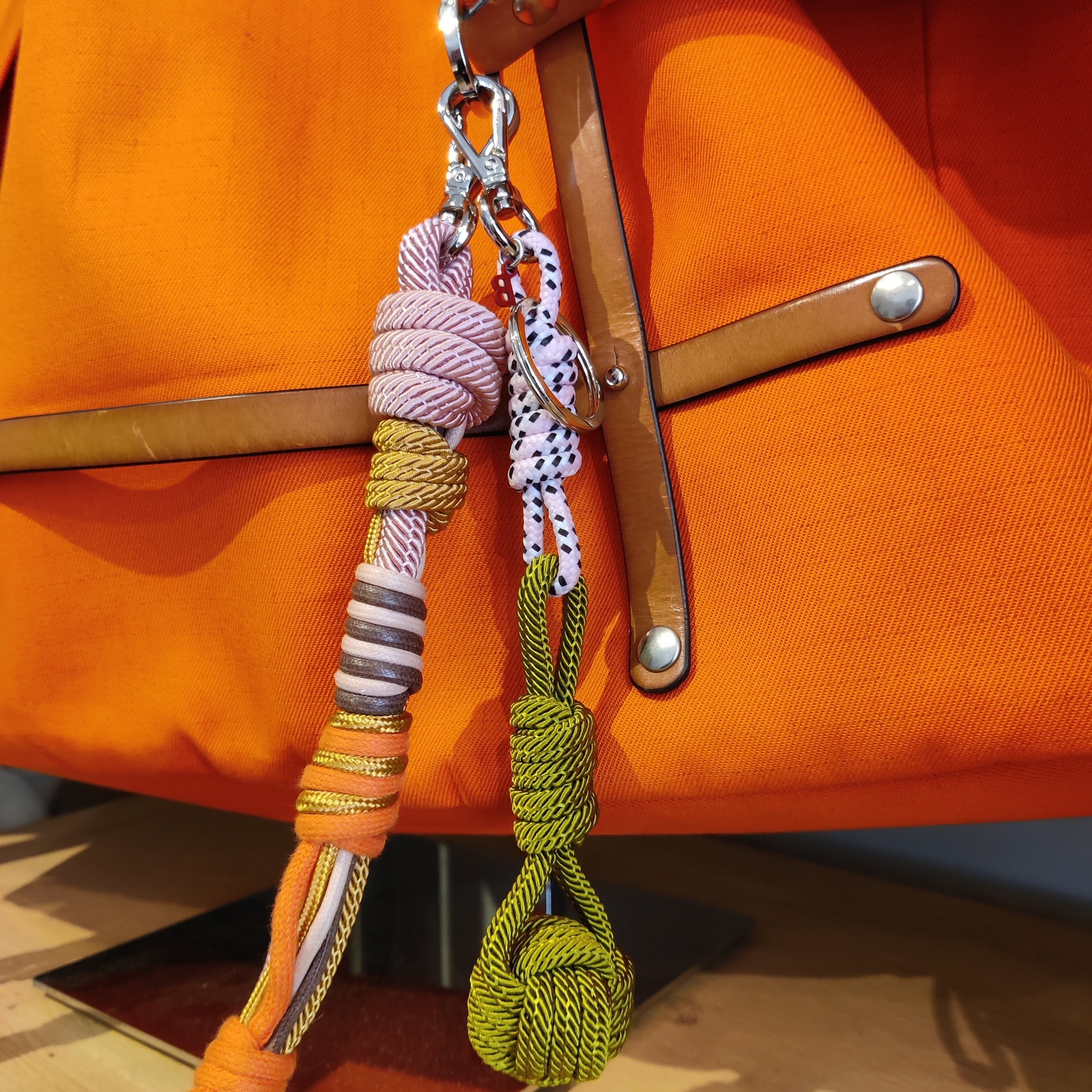 A light pink and khaki sailor ball keychain put on an orange bag. 