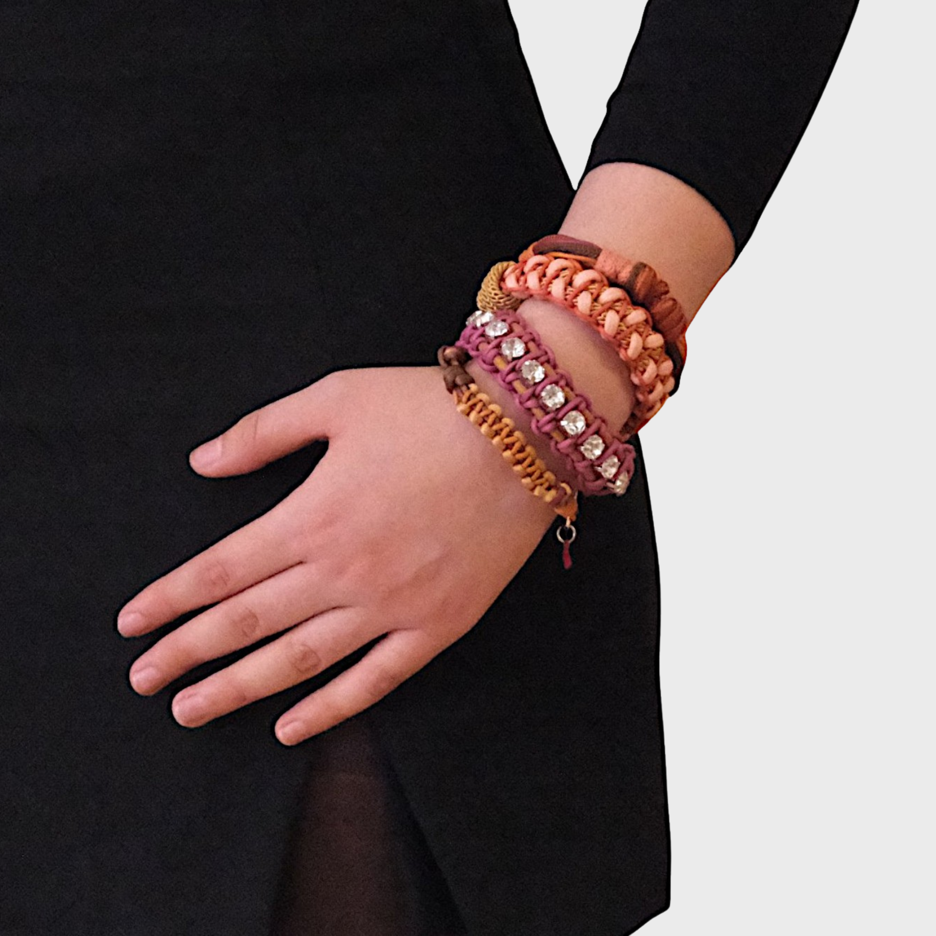 A model wearing several bracelets including the pink and mustard Juliette bracelet with small white beads