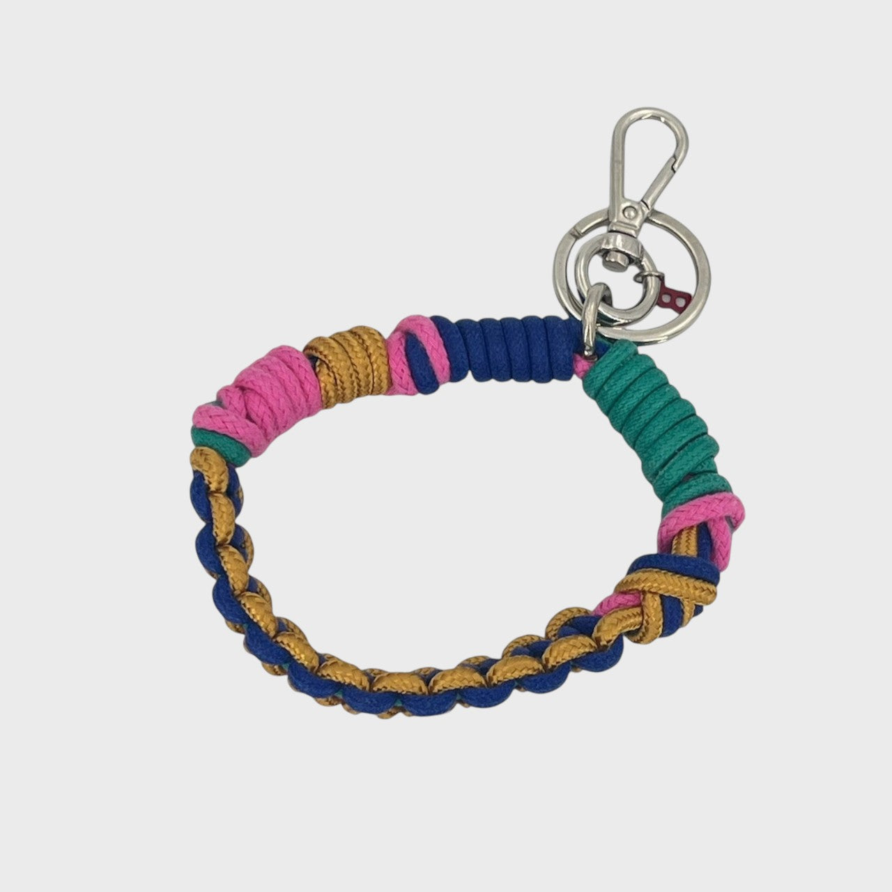 A woven macramé key chain with pink, blue, green and yellow patterns, inspired by celtic knots, finished with silver-tone metal hardware.