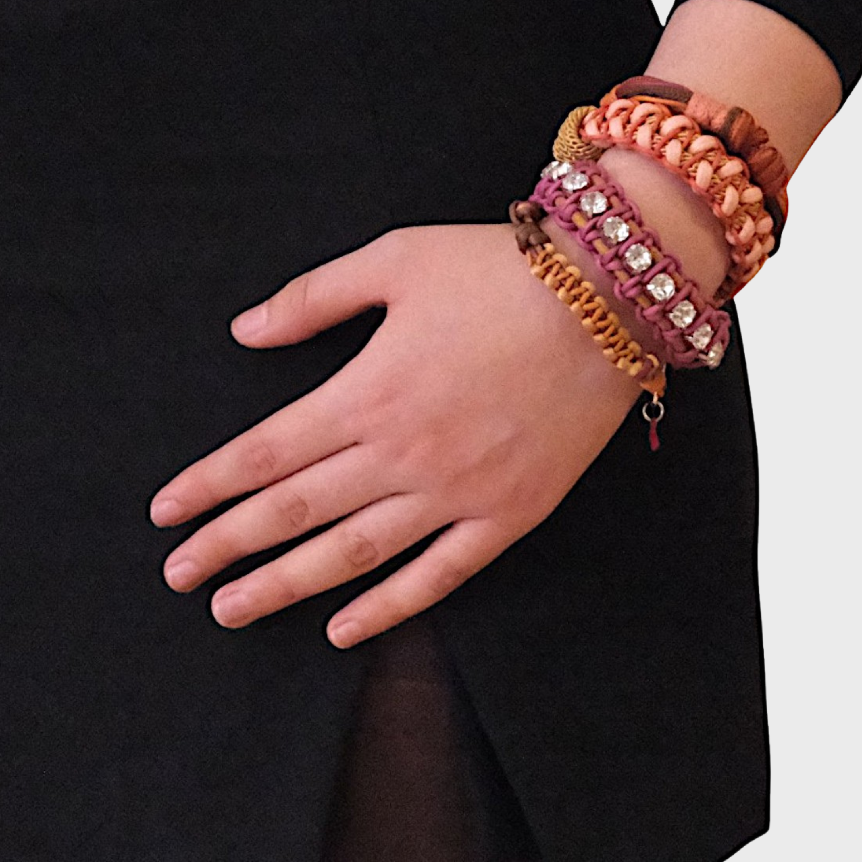 A model wearing several bracelets including the pink and brown knot bracelet