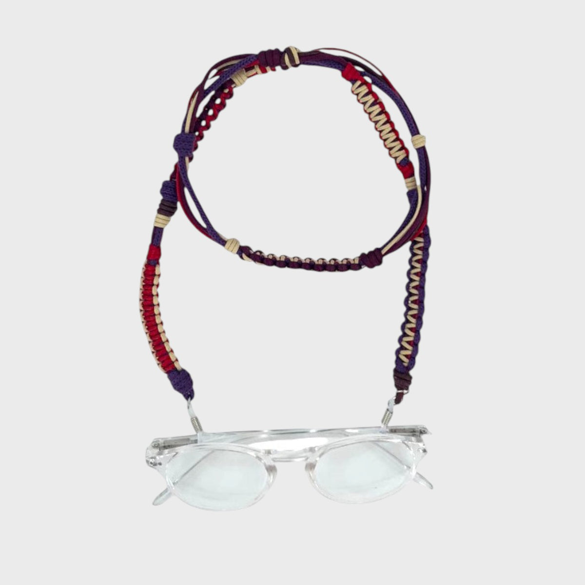 Colorful woven eyeglass strap with a pair of glasses on a white background