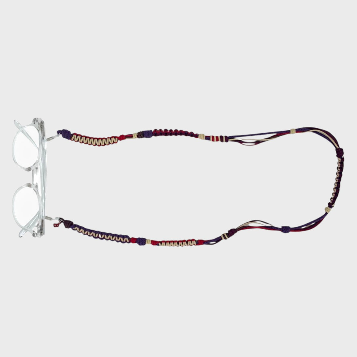 Red, purple and beige woven eyeglass strap with a pair of glasses on a light gray background