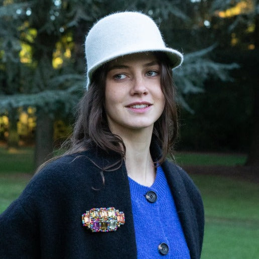 A model wearing the embroidered brooch with stones of the color of the rainbow. 