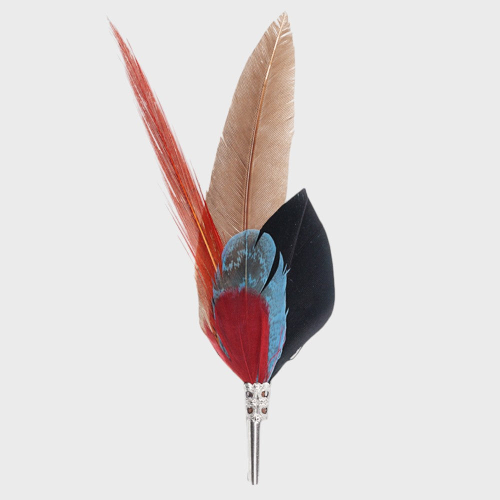 Red, white, black and blue feathered brooch on a light gray background 