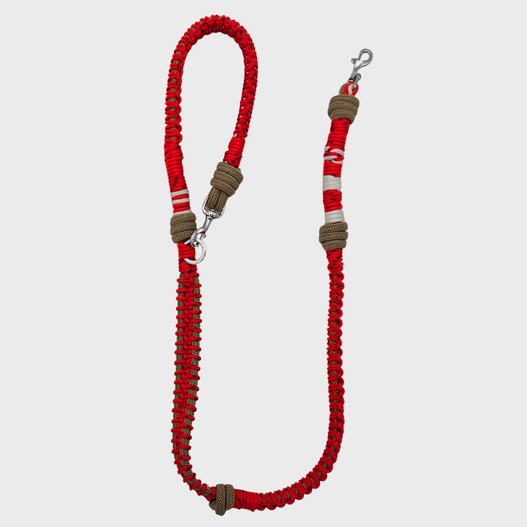 A braided macramé dog leash with red, brown, and white woven sections, and a silver metal hardware.