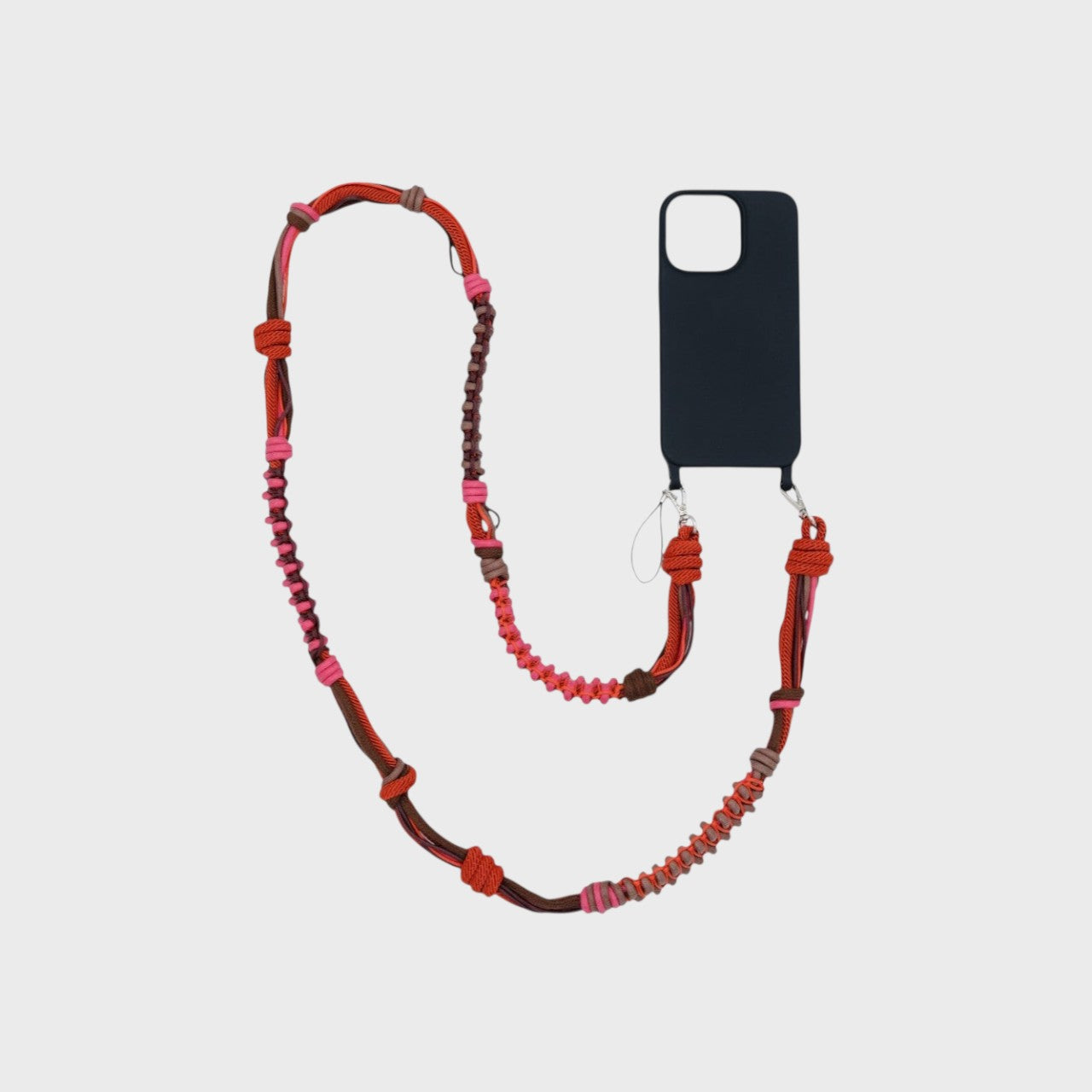 Red, Brown and pink  macramé thick woven phone lanyard with a black phone case on a white background. 
