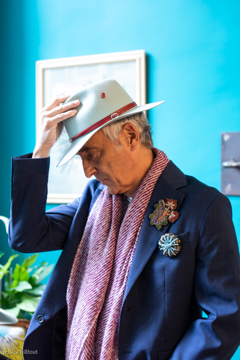 A man wearing a cashmere red shawl or scarf. 