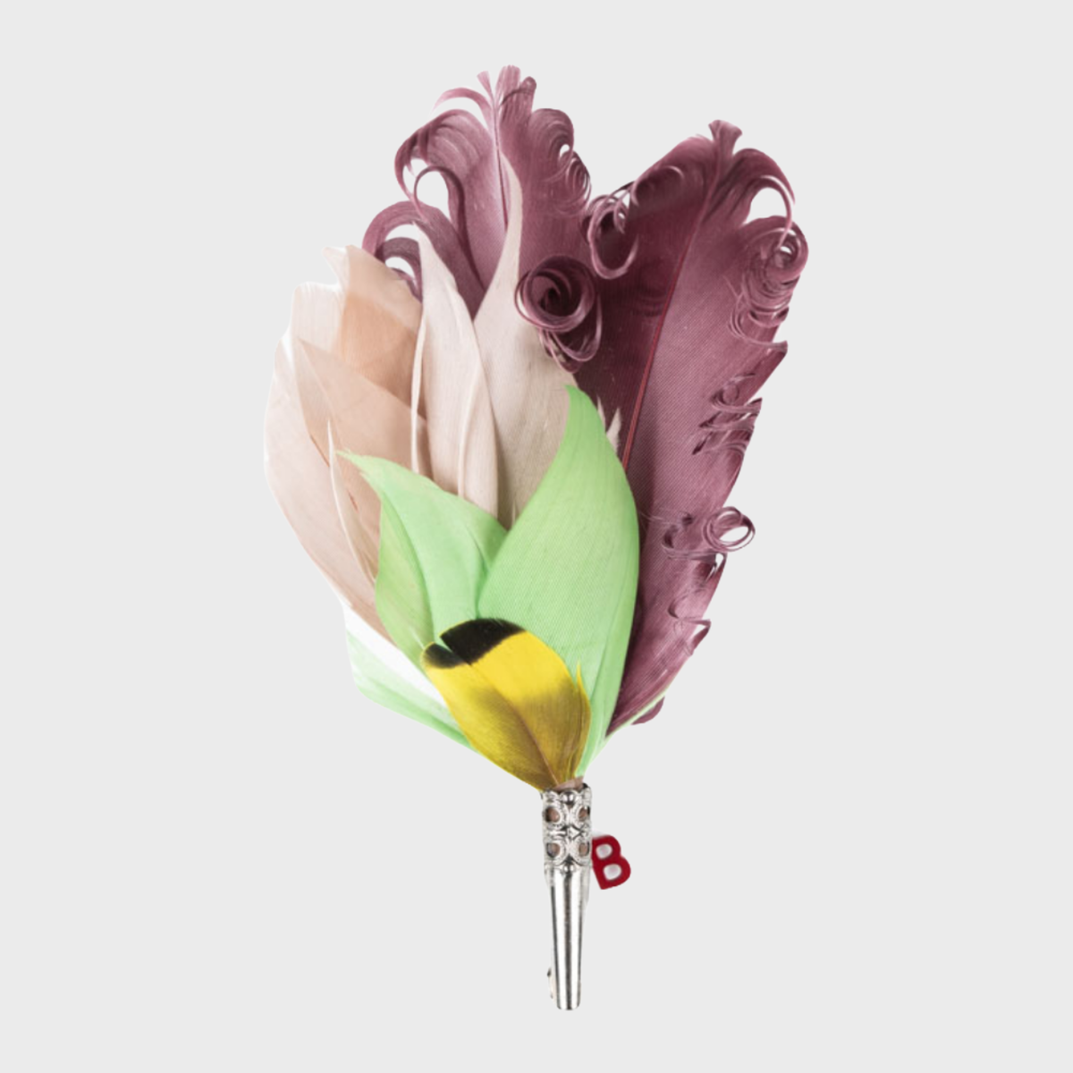 A feather brooch with curled purple feathers and green, beige and yellow feathers. 
