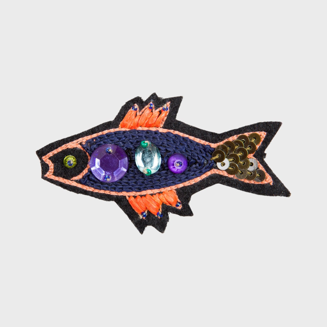 An embroidered brooch representing a navy sardine with orange details. 