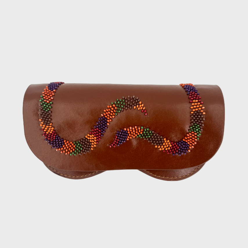 A brown leather eyeglasses case featuring a decorative wavy pattern of multicolored seed beads in orange, green, red, and blue representing a snake, set against a plain light gray background.