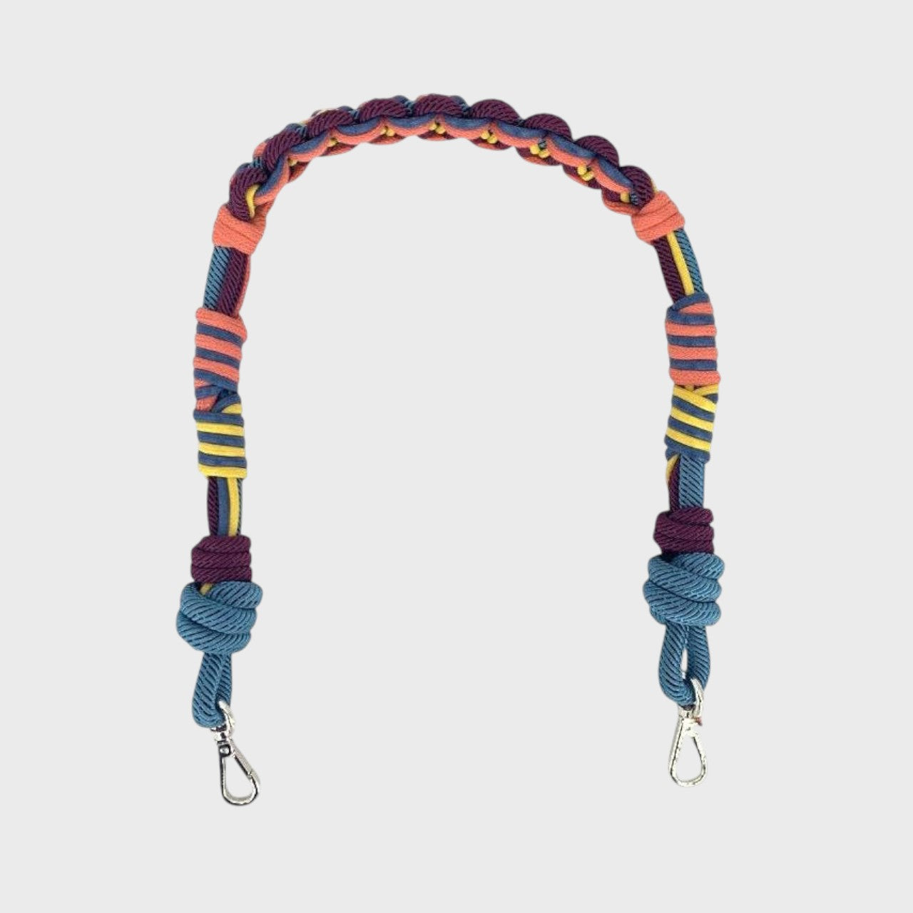 Multicolored braided macramé bag strap in coral, blue, yellow and purple with metal hooks on a light gray background.