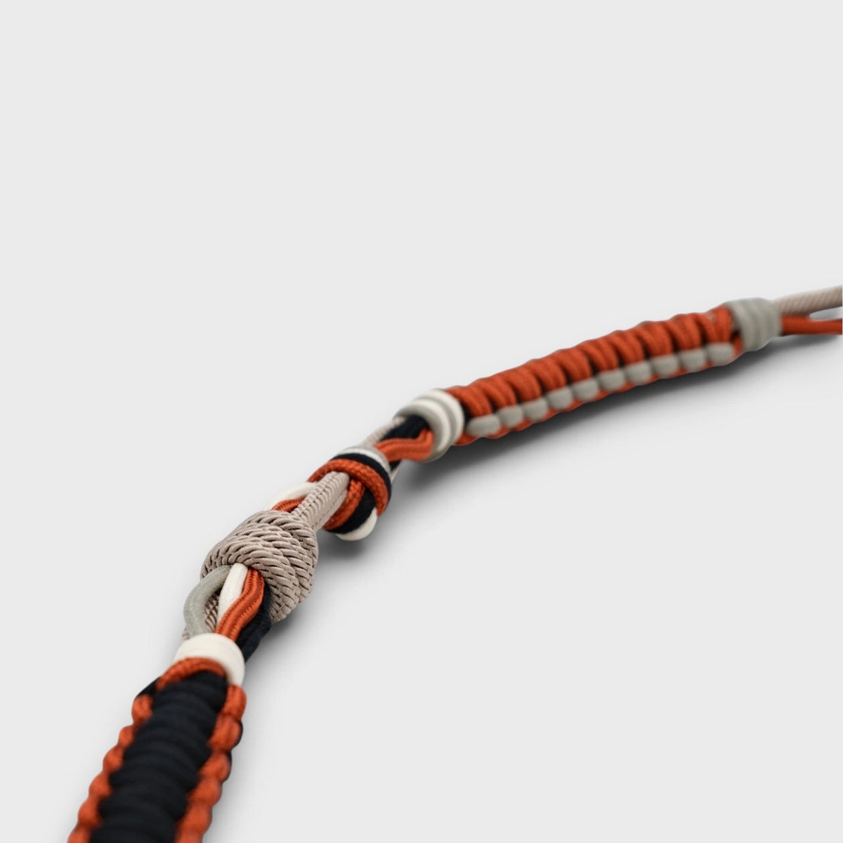 A macramé terracotta black, grey and white bag strap. 