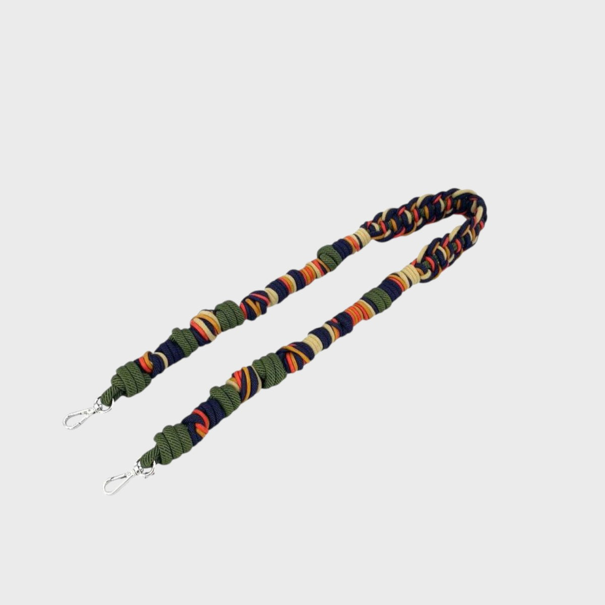 Multicolored macramé bag strap on a light gray background