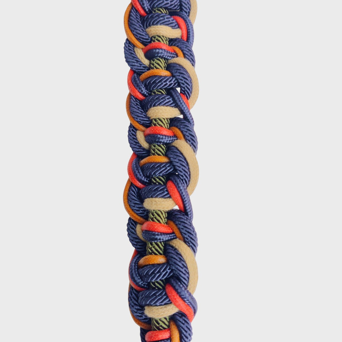 Multicolored braided macramé bag strap on a light gray background