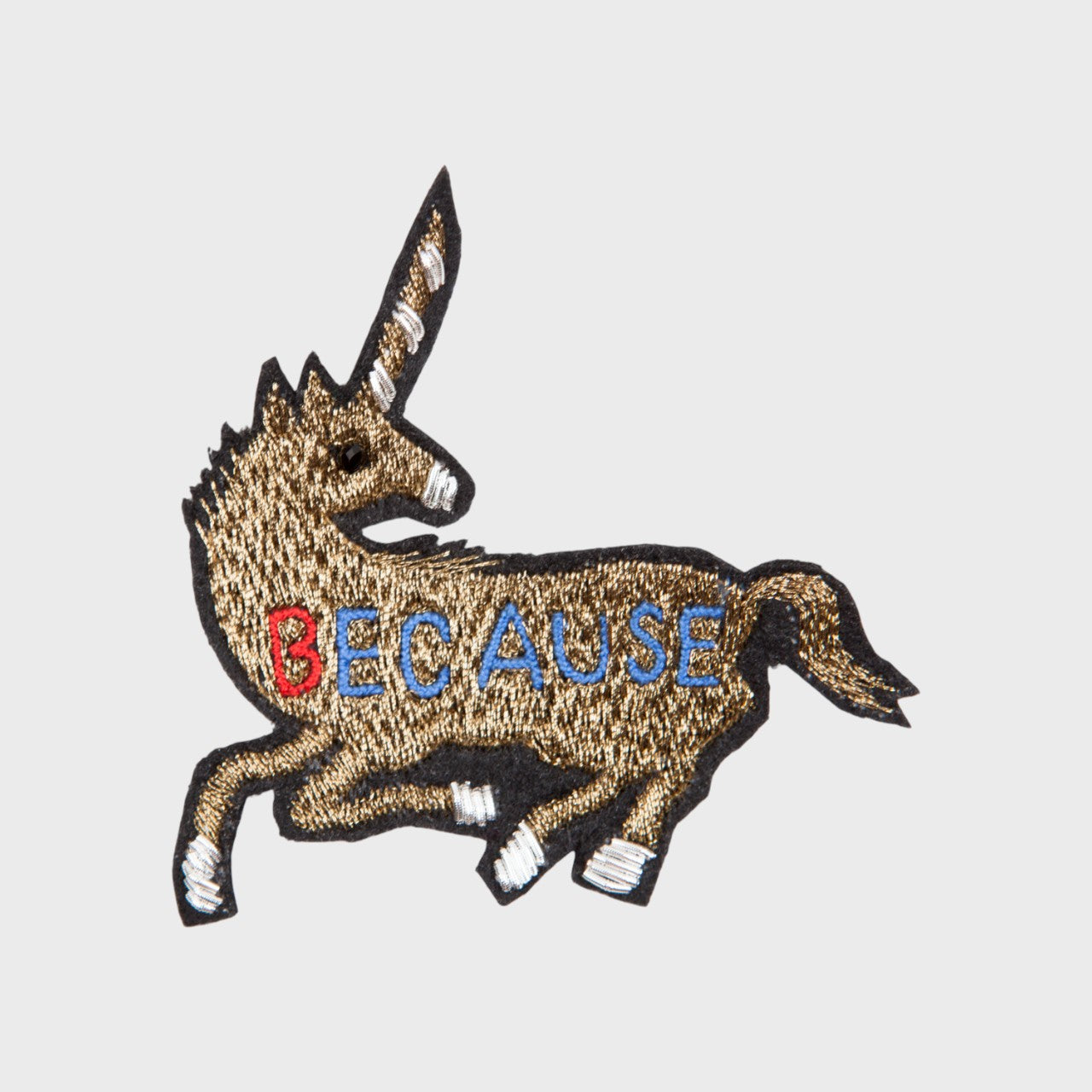 An embroidered brooch representing a golden unicorn. 