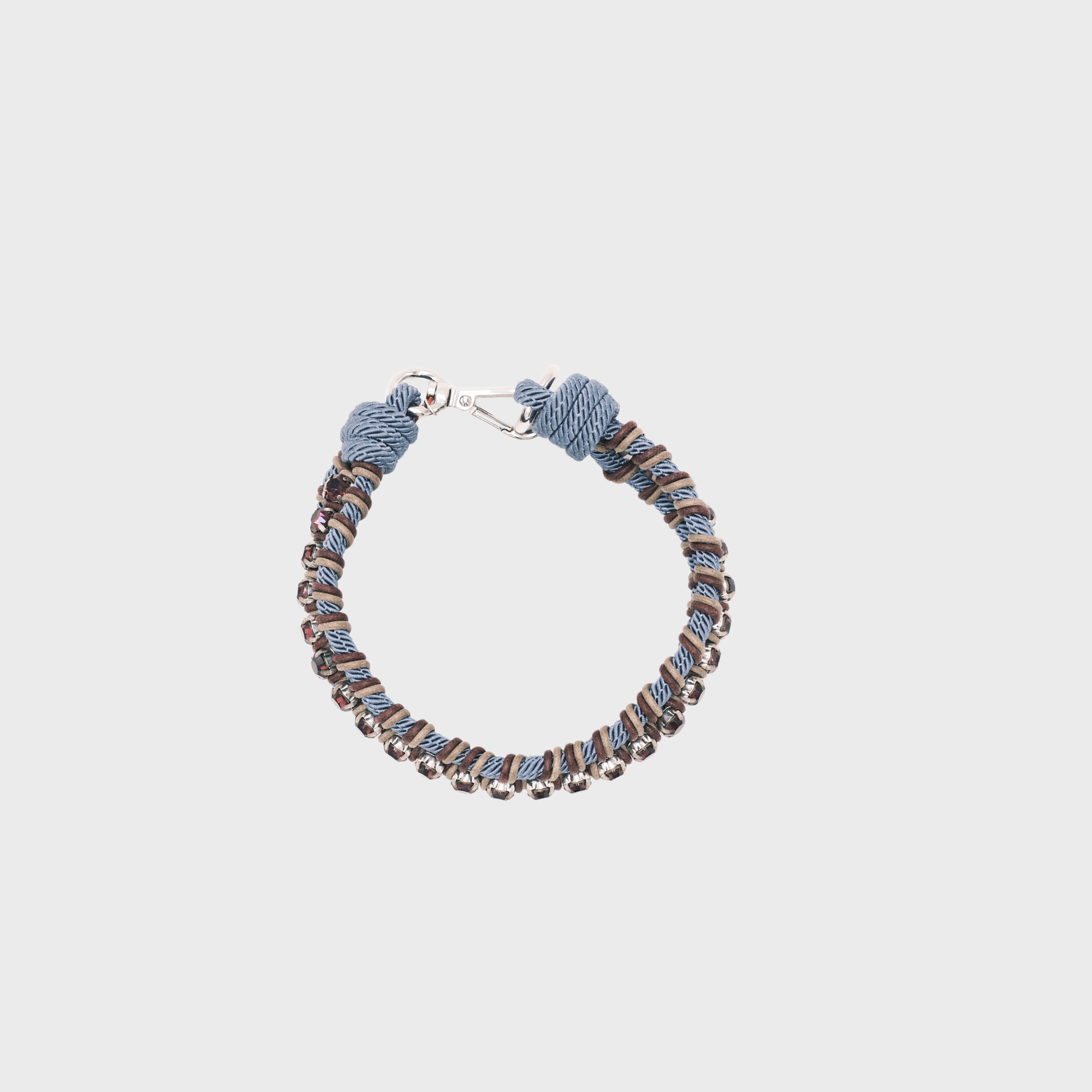 A handmade macramé collar with a silver clasp, featuring blue, brown, and beige twisted cords, with purple beads.