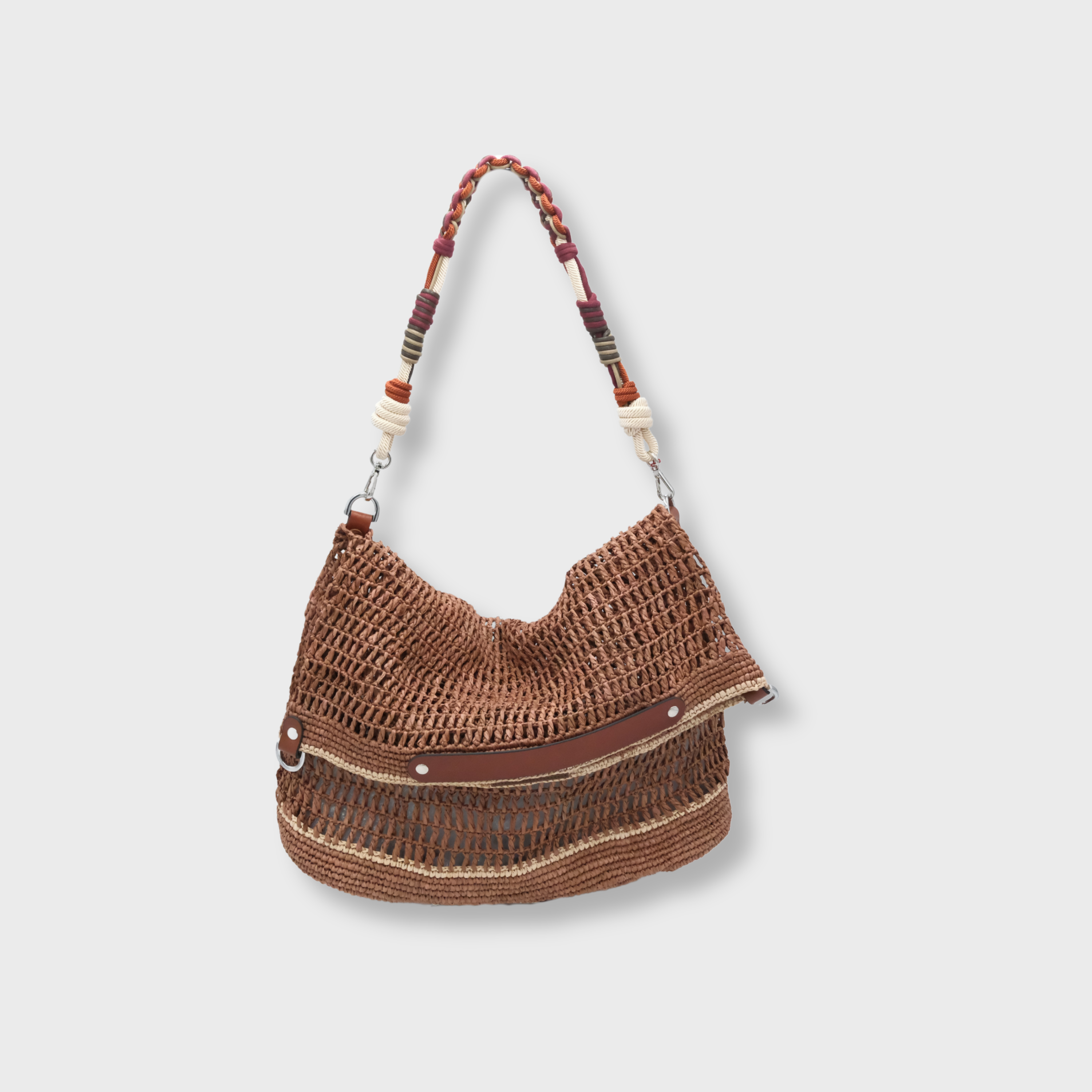 A Brown raffia Colin Tote Bag with beige stripes, hanging by a burgundy, white and orange macramé strap. 