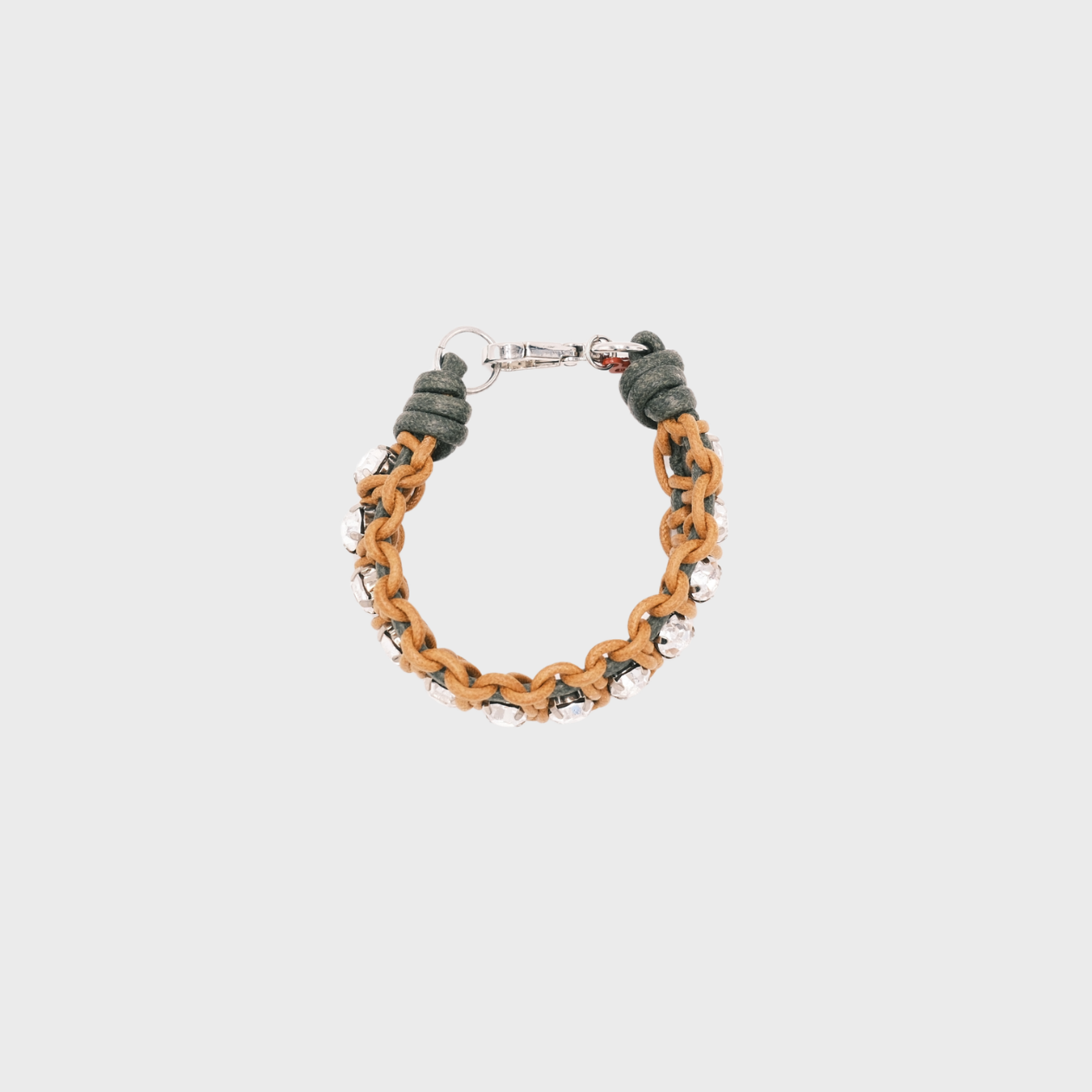A handmade macramé woven bracelet featuring a mix of brown, and green threads, accented with small white beads and a silver clasp.