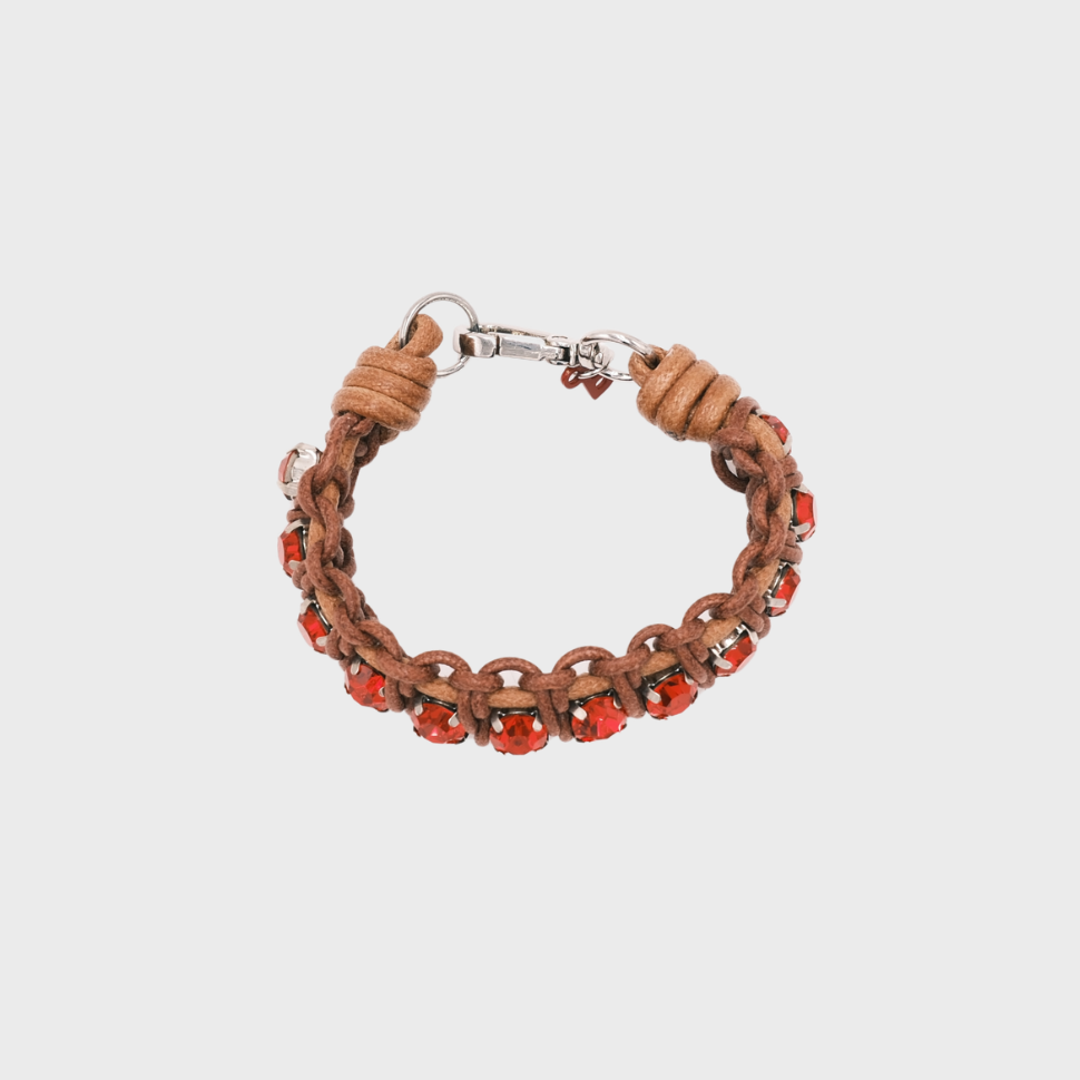 A handmade macramé woven bracelet featuring a mix of brown threads, accented with small red beads and a silver clasp.