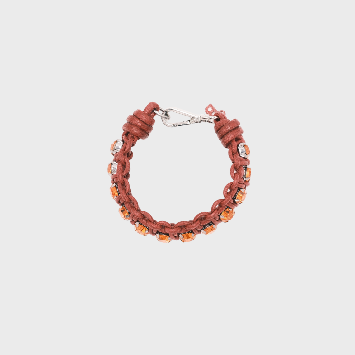 A handmade macramé woven bracelet featuring a mix of pink threads, accented with small orange beads and a silver clasp.