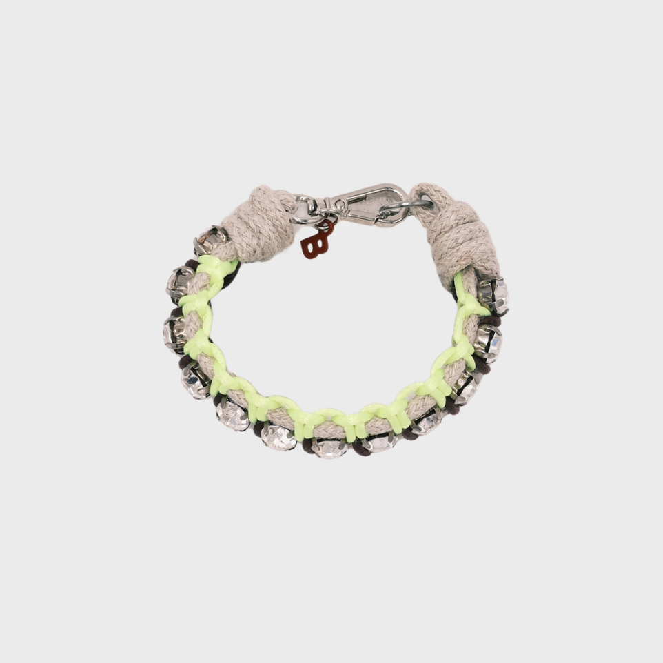 A handmade macramé woven bracelet featuring a mix of brown, and neon yellow and beige threads, accented with small white beads and a silver clasp.