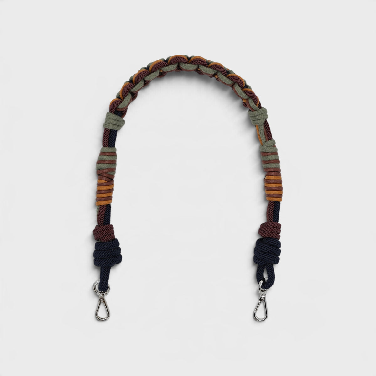 A multi-colored macrame bag strap with silver metal clips at the bottom, shown on a light gray background.