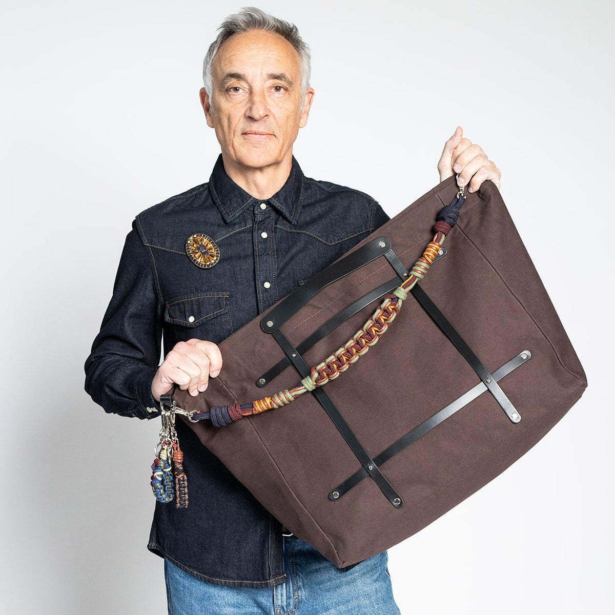 A man carrying a chocolate bag with a macramé strap in Vineyard. 
