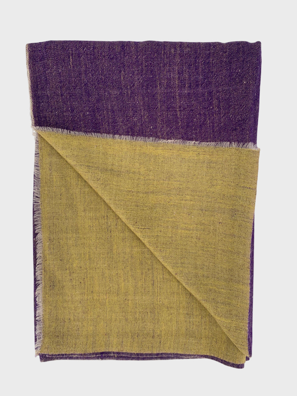 Folded cashmere shawl with purple top and yellow bottom on a white background