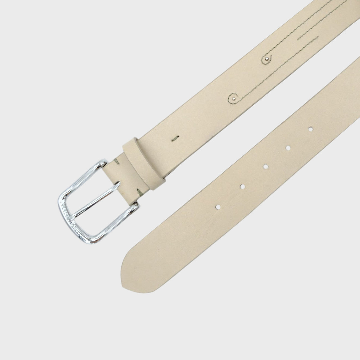 Beige leather belt with stitched details on it and a silver buckle on a light gray background