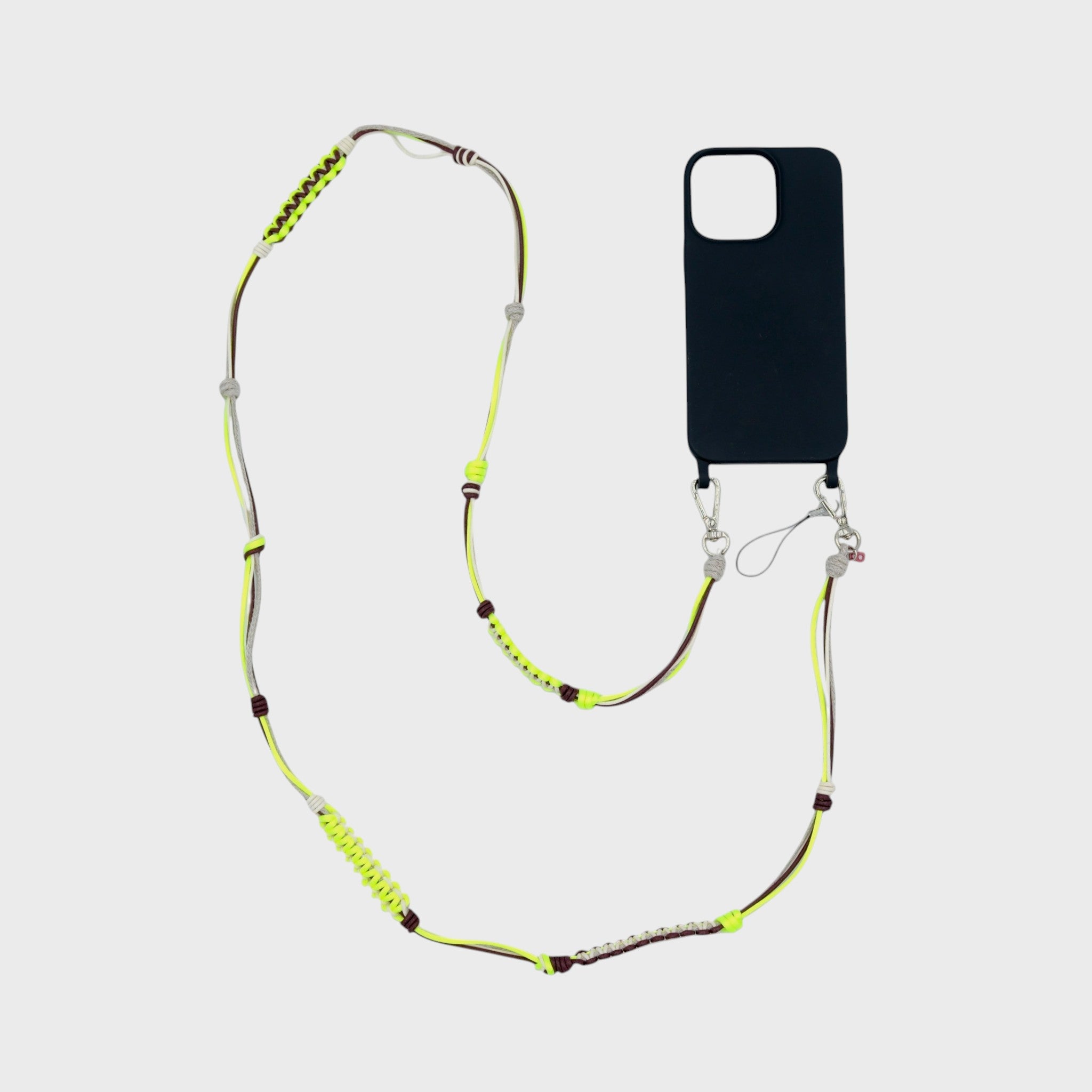 Neon yellow, beige and brown macramé woven phone lanyard with a black phone case on a white background