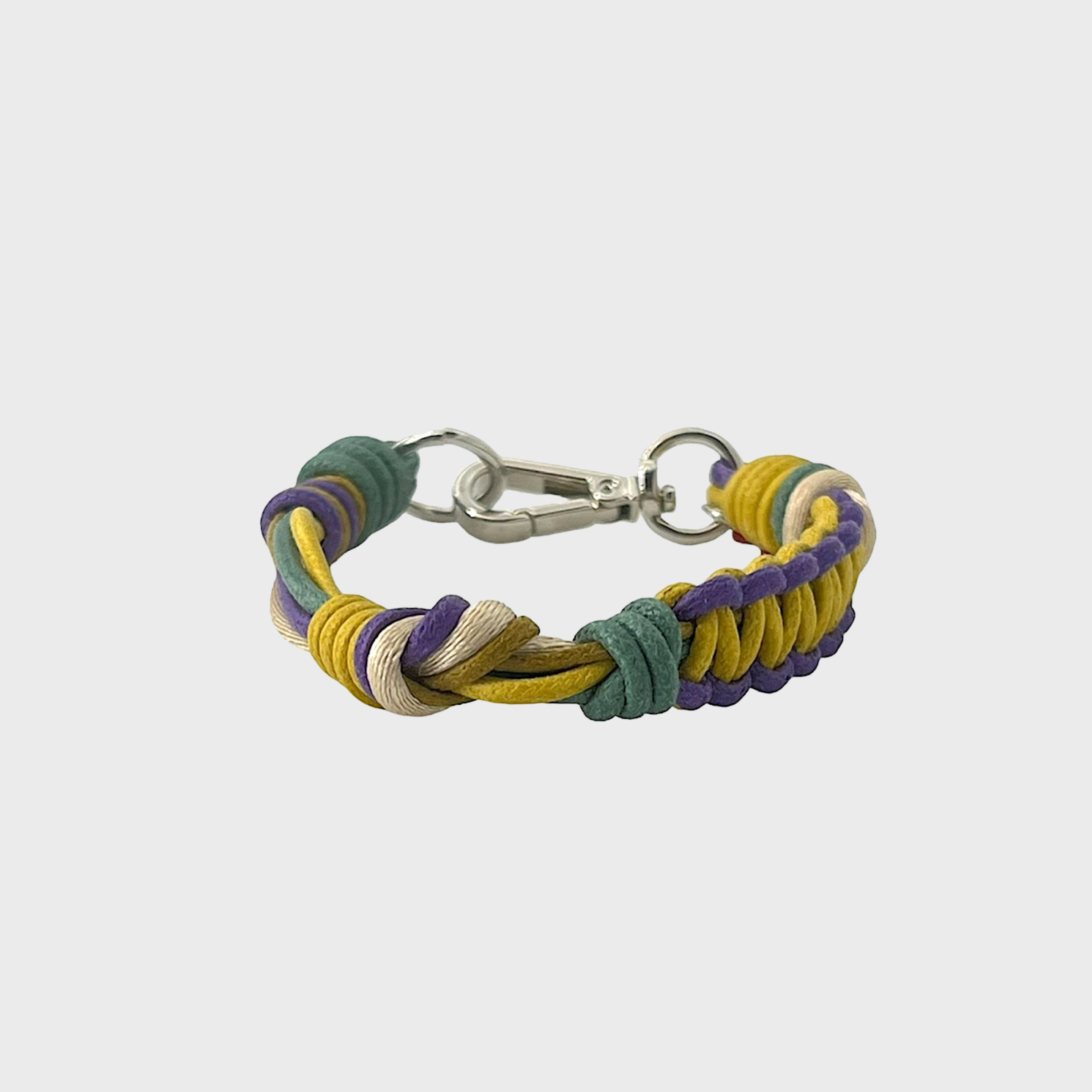 A thin braided bracelet with yellow, purple and green macramé, featuring a silver metal  clasp. 