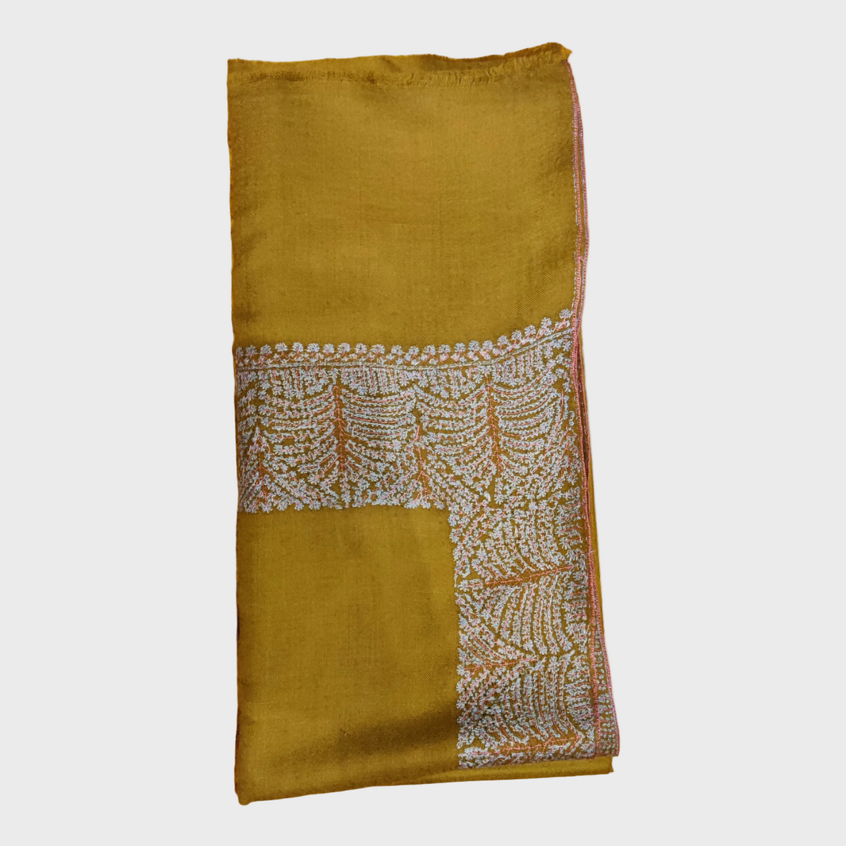 Mustard yellow cashmere shawl with intricate white pattern on a light gray background