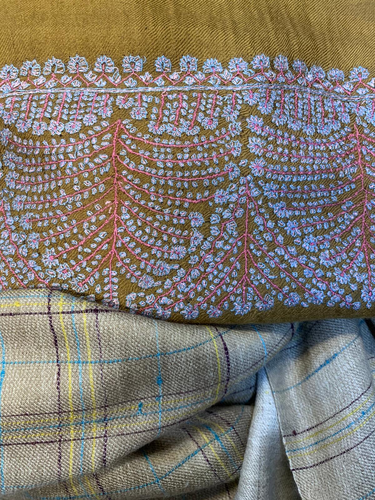 A yellow cashmere shawl with floral white details. 