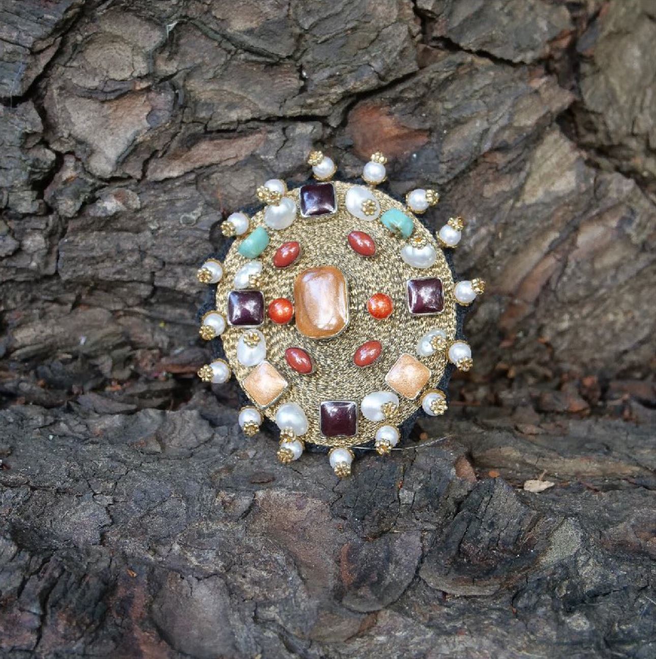 An embroidered golden yourte put against a rock background. 