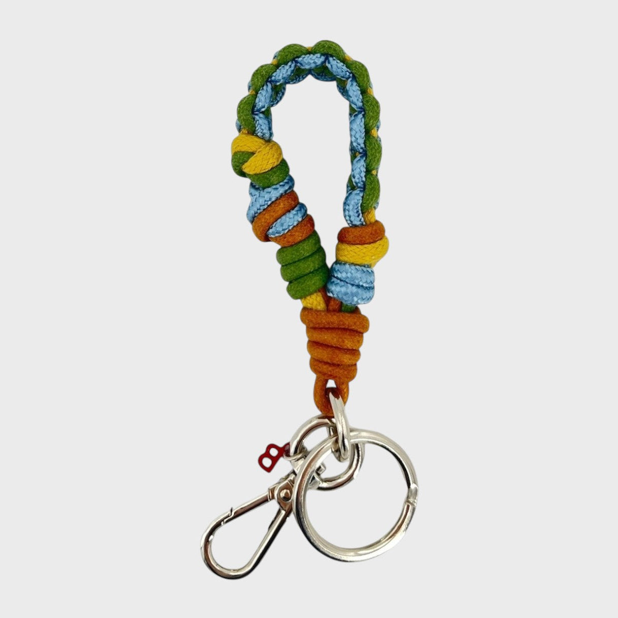 A braided macramé keychain or bag clip in green, blue yellow and brown, featuring a silver metal clasp. 