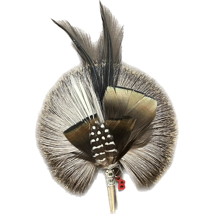 A feather brooch with black and grey feathers. 