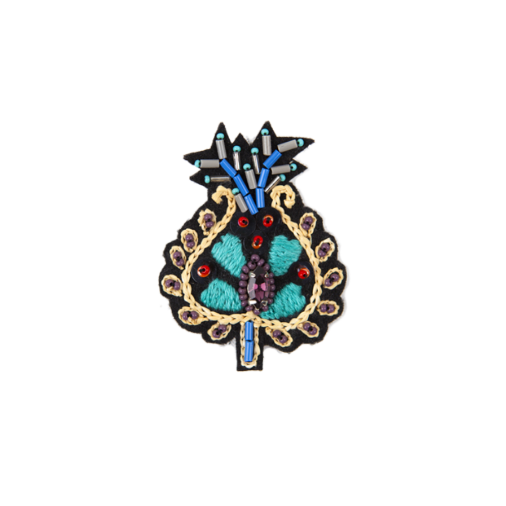 A colorful floral-patterned embroidered brooch with a prominent blue and turquoise color scheme, hand embroidered in India.