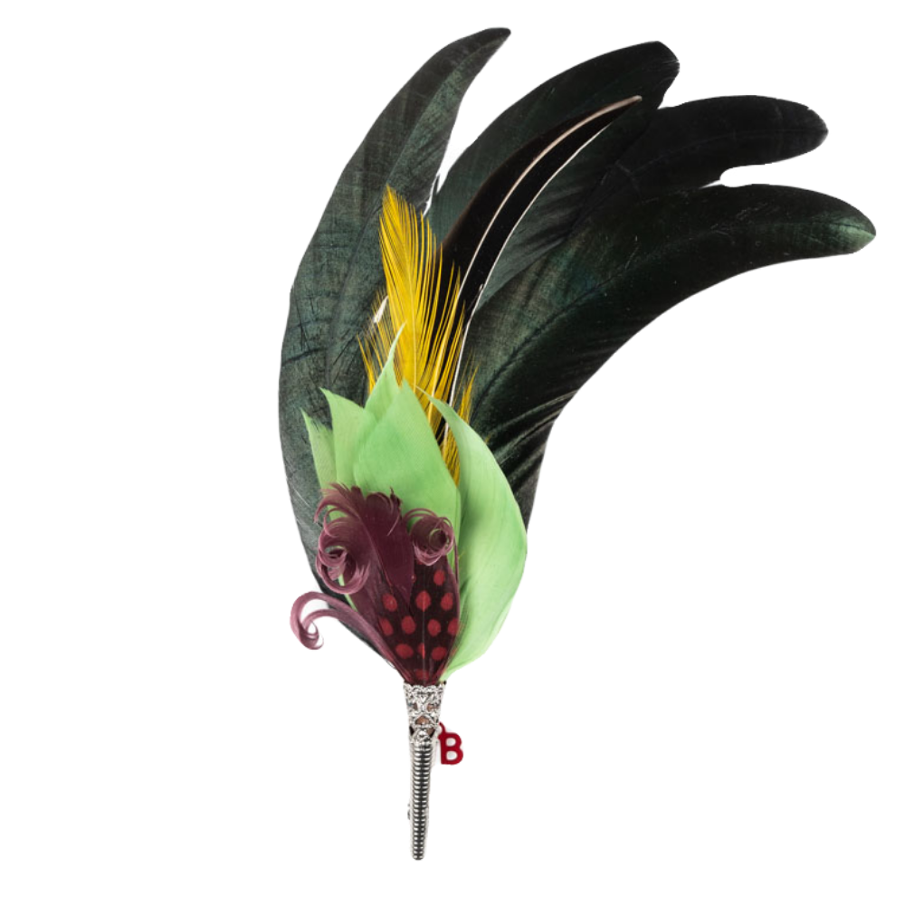 A feather brooch with green, purple, yellow and black feathers. 