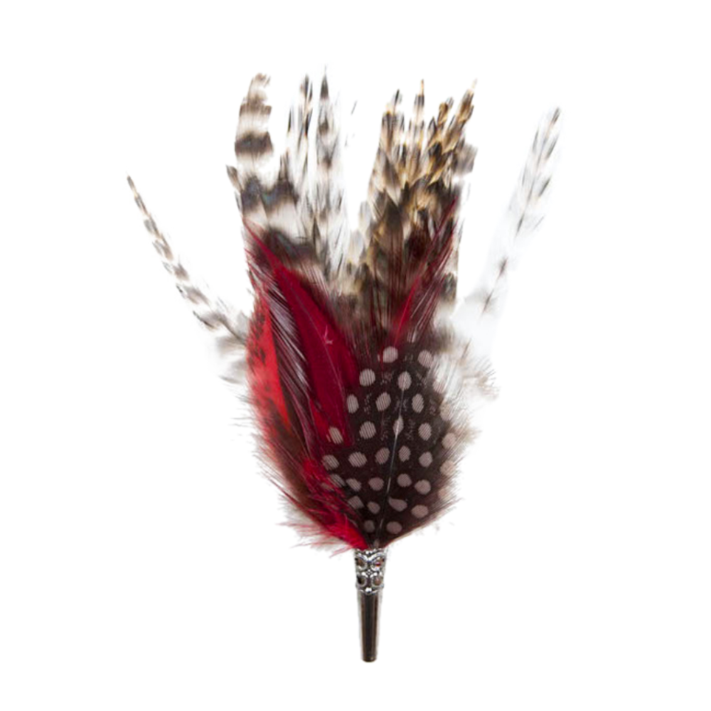 A brooch featuring a combination of natural and dyed feathers in red, black, and white, attached to a pin. 