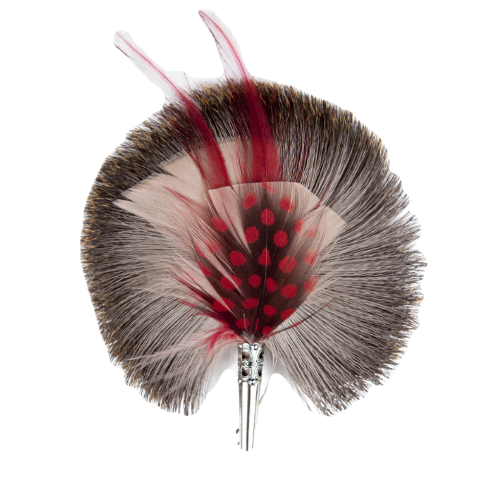 A feather brooch with grey, red and pink feathers with a silver metal clasp. 