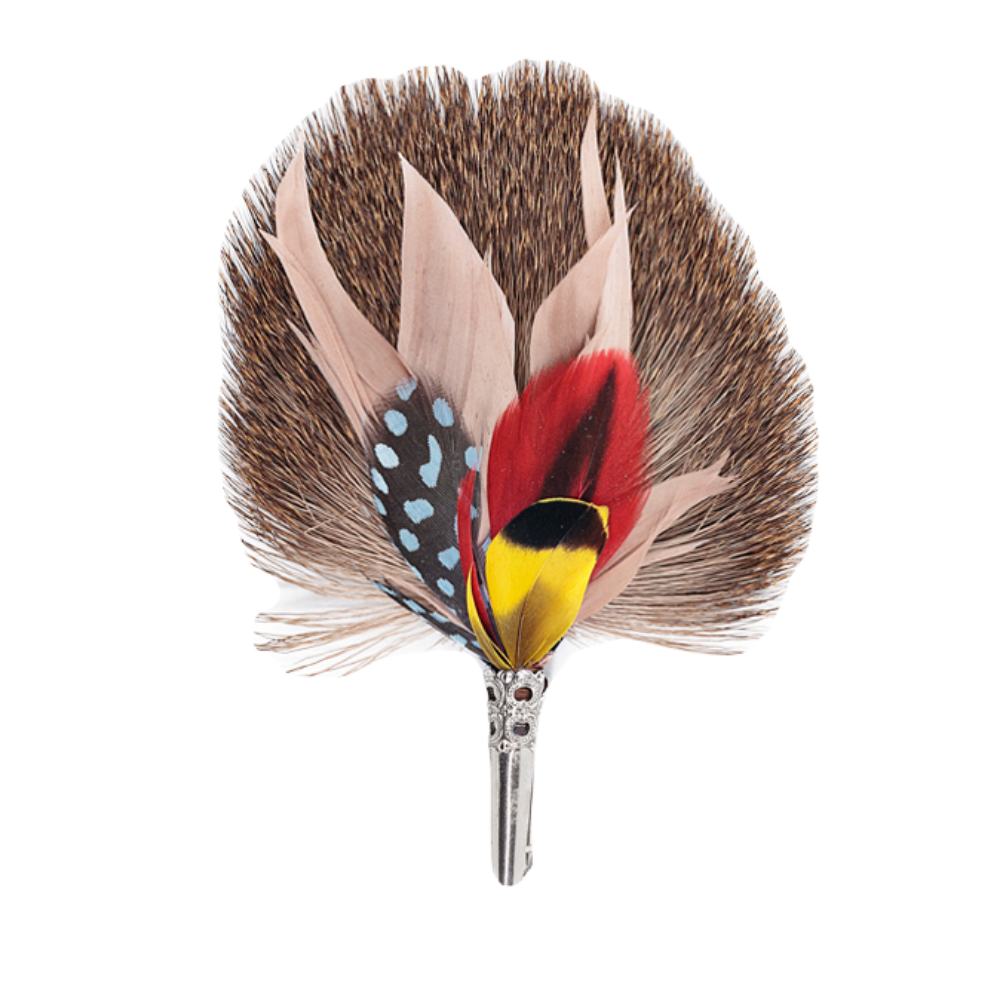 A feather brooch with yellow, red, blue, brown and pink feathers and a silver clasp. 